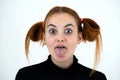 Closeup portrait of a funny redhead teenage girl with childish hairstyle sticking out her tongue isolated on white backround Royalty Free Stock Photo