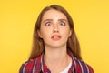 Closeup portrait of funny silly ginger woman in checkered shirt looking up cross eyed with stupid dumb face Royalty Free Stock Photo