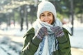 Closeup portrait of funny smiling woman in woolen hat and long warm scarf at snowly winter park Royalty Free Stock Photo