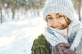 Closeup portrait of funny smiling woman in woolen hat and long warm scarf at snowy winter park Royalty Free Stock Photo