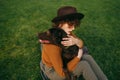 Closeup portrait of a girl sitting on a green lawn and hugging a beautiful brown dog, top view. Attractive lady hugs the puppy Royalty Free Stock Photo