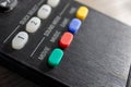 A closeup portrait of the green movie sound mode button on a television remote control. There are other colored mode buttons on Royalty Free Stock Photo