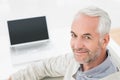 Closeup portrait of a grey haired man with laptop