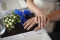 Closeup portrait of groom holding brides hand on table near bouquet Royalty Free Stock Photo