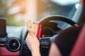 Closeup portrait hand woman sitting in her new white car showing credit card and holding dollar  Personal transportation purchase Royalty Free Stock Photo