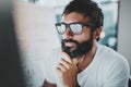 Closeup portrait of Handsome bearded man working at the modern office loft.Horizontal. Blurred background.Cropped. Royalty Free Stock Photo