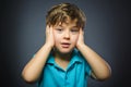 Closeup Portrait of handsome boy with astonished expression while standing against grey background