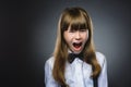 Closeup Portrait of handsome girl with astonished expression while standing against grey background Royalty Free Stock Photo