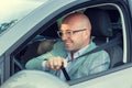 Closeup portrait handsome man happy smiling in his car asking showing you to fasten safety belt. Safe trip transportation and Royalty Free Stock Photo