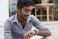 Closeup portrait handsome man looking to his wristwatch frustrated that his girl friend partner client is late to the date meeting Royalty Free Stock Photo