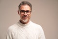 Closeup portrait of handsome middle aged man with folded arms, wearing eyeglasses, standing on white grey background, looking at Royalty Free Stock Photo