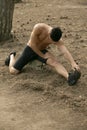 Closeup portrait of a handsome sportsman doing stretching exercises in the park. Healthy lifestyle concept Royalty Free Stock Photo