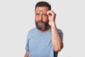 Closeup portrait of handsome young bearded man with glasses, wearing casual clothing, standing over white studio background, Royalty Free Stock Photo