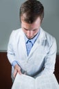 Closeup portrait of handsome young doctor reading Royalty Free Stock Photo