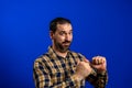 Closeup portrait of handsome young guy in blue shirt pointing to himself showing that he is the man, a stud, isolated on blue Royalty Free Stock Photo