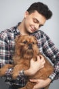 Closeup portrait handsome young hipster man, kissing his good friend red dog isolated light background. Positive human emotions, f Royalty Free Stock Photo