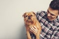 Closeup portrait handsome young hipster man, kissing his good friend red dog isolated light background. Positive human emotions, f Royalty Free Stock Photo