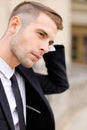 Closeup portrait of handsome young man wearing balck suit and tie.