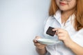 Closeup portrait of happy beautiful Asian young woman with blonde red hair and white shirt is smiling and holding dark chocolate, Royalty Free Stock Photo