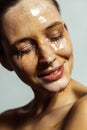 Closeup portrait of happy beautiful young brunette woman with freckles and honey on face with closed eyes and toothy smile Royalty Free Stock Photo