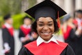 Closeup portrait of happy black lady student wearing graduating costume