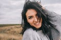 Closeup portrait of happy brunette young woman wearing gray sweater being playful and carefree with beautiful toothy smile and Royalty Free Stock Photo