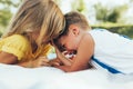 Closeup portrait of happy children playing on the blanket outdoors. Little boy and cute little girl smiling in the park. Adorable Royalty Free Stock Photo