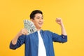 Closeup portrait, happy, excited successful senior lucky elderly man holding money dollar bills in hand isolated yellow background Royalty Free Stock Photo