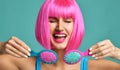 Closeup portrait of happy fashion brunette woman hold two small pink blue yellow small hair comb brush laughing in pink wig Royalty Free Stock Photo