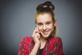 Closeup Portrait of happy girl with mobile or cell phone on gray background Royalty Free Stock Photo