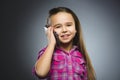 Closeup Portrait of happy girl with mobile or cell phone on gray background Royalty Free Stock Photo