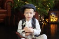 Closeup portrait Happy little boy hugs Figurine of a rocking horse on Christmas. Smiling Little blond boy in a white shirt with a