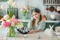 CloseUp portrait of happy little girl with bouquet flowers in kitchen. Girl and flowers. Child is preparing for Easter. Girl with Royalty Free Stock Photo