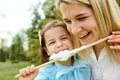 Closeup portrait of happy little girl having fun and eating cotton candy with her mother in the park. Royalty Free Stock Photo