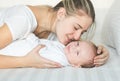 Closeup portrait of happy mother kissing her baby boy on bed Royalty Free Stock Photo