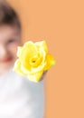 Closeup portrait happy smiling boy with orange rose. Beautiful little boy toddler giving a flower Mother`s day concept. boy Royalty Free Stock Photo