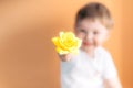 Closeup portrait happy smiling boy with orange rose. Beautiful little boy toddler giving a flower Mother`s day concept. boy Royalty Free Stock Photo