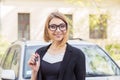 Closeup portrait happy woman, buyer near her new car showing key Royalty Free Stock Photo