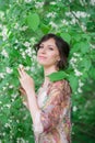 Closeup portrait of happy woman in green spring foliage. Pretty Woman on Floral Background. Spring Beauty Royalty Free Stock Photo