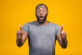 Closeup portrait of happy young handsome man looking shocked surprised open mouth eyes, isolated on yellow background. Positive Royalty Free Stock Photo