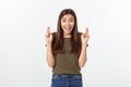 Closeup portrait hopeful beautiful woman crossing her fingers, open eyes, hoping, asking best isolated on gray wall