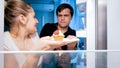 Closeup portrait of young hungry couple fighting for last piece of cake at night Royalty Free Stock Photo