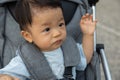 Happy and cute Asian Chinese baby boy sitting on stroller at park during evening Royalty Free Stock Photo