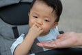 Happy and cute Asian Chinese baby boy sitting on stroller at park during evening Royalty Free Stock Photo