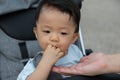 Happy and cute Asian Chinese baby boy sitting on stroller at park during evening Royalty Free Stock Photo