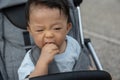 Happy and cute Asian Chinese baby boy sitting on stroller at park during evening Royalty Free Stock Photo