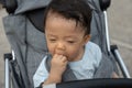 Happy and cute Asian Chinese baby boy sitting on stroller at park during evening Royalty Free Stock Photo