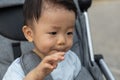 Happy and cute Asian Chinese baby boy sitting on stroller at park during evening Royalty Free Stock Photo