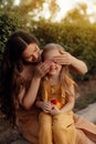 Closeup portrait of a little baby girl and mother on wheat summer field. Adventure, travel, tourism, hike and people concept - Royalty Free Stock Photo