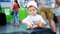 Closeup portrait of little boy holding and playing with miniature wooden airplane. Child traveling. Young tourist. Royalty Free Stock Photo